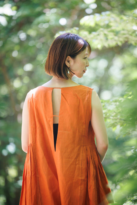 sunset orange summer day dress with lader stitch, side ruffle panels and a deep v back detail