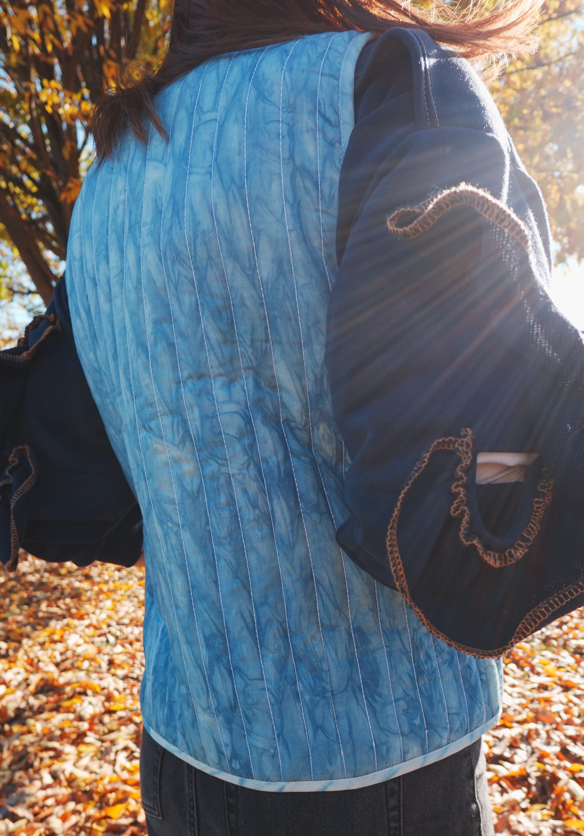 Blue hand quilted reversible vest style jacket with hand block print fabric on one side and hand done shibori on the other side. it has pockets on both sides. 