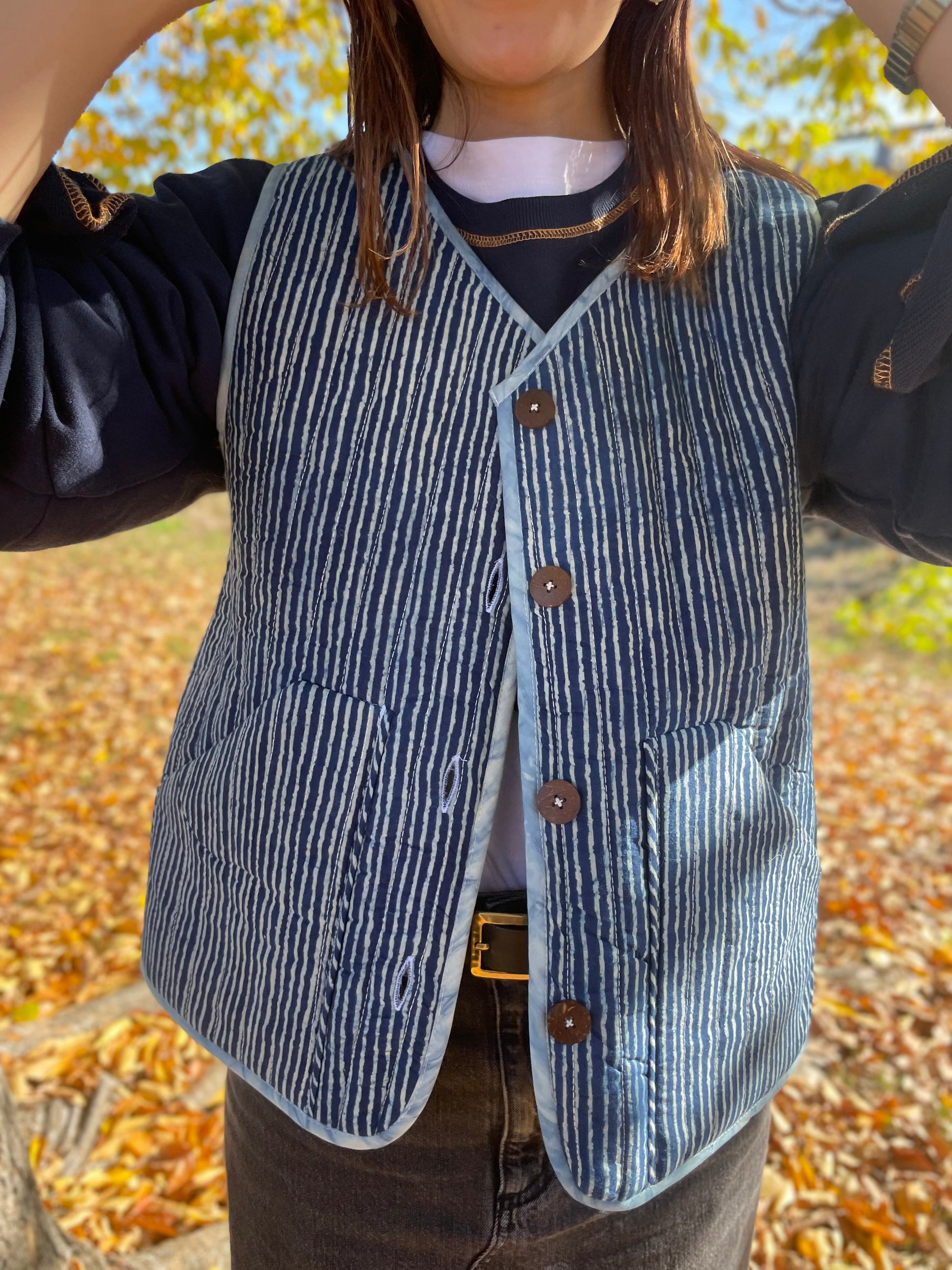 Blue hand quilted reversible vest style jacket with hand block print fabric on one side and hand done shibori on the other side. it has pockets on both sides. 