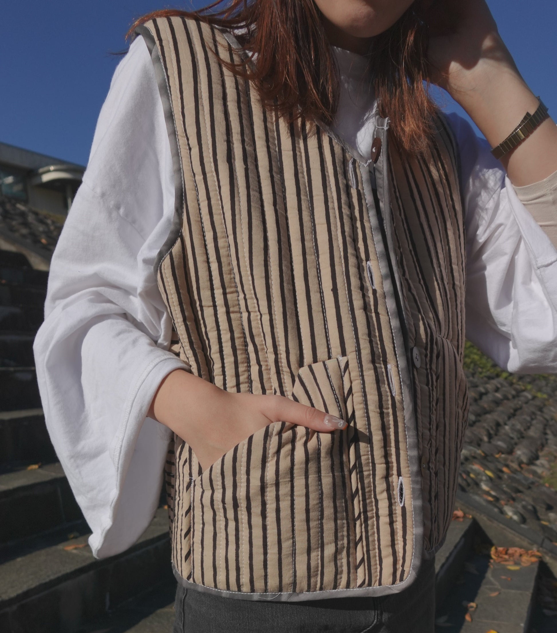 Blue hand quilted reversible vest style jacket with hand block print fabric on one side and hand done shibori on the other side. it has pockets on both sides. 