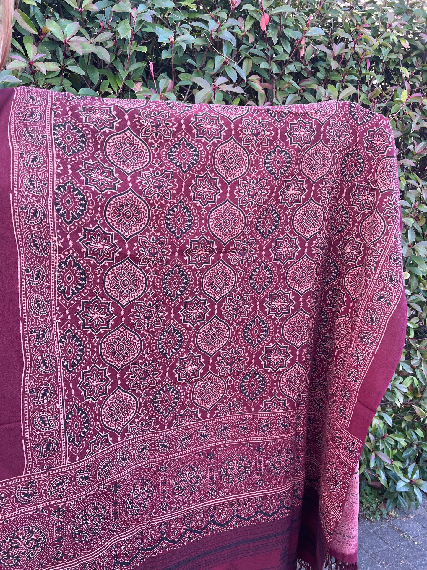 hand woven merino wool shawl with all over ajrakh hand block print in shades of deep red using natural colours. 